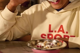a boy eating food from a hydro flask bowl