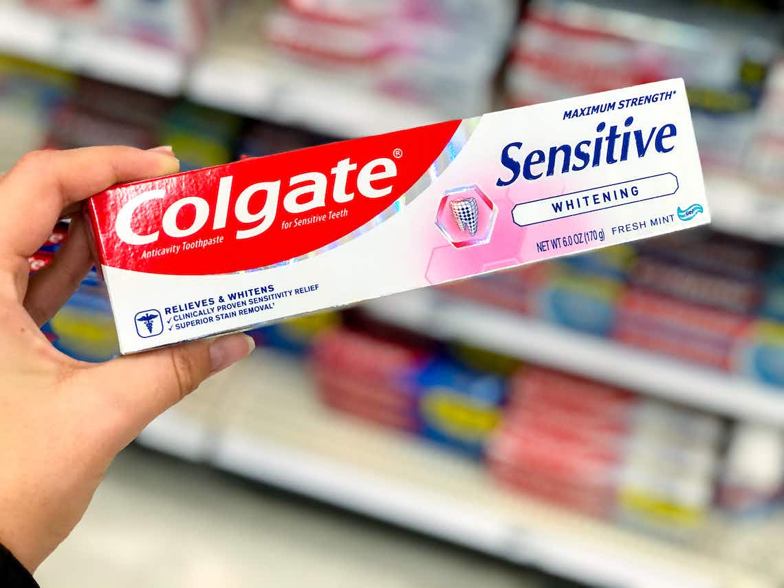 hand holding colgate sensitive toothpaste