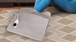 a person with their feet in a grey foot warmer pad
