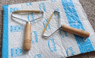 Two wooden lint removers on an Amazon package.