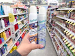 hand holding two batiste dry shampoos in walgreens
