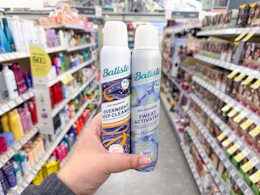 hand holding two batiste dry shampoos in walgreens