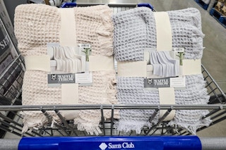 2 neutral colored throw blankets in a cart