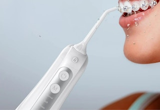 white water flosser being used on a woman with braces