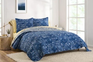 lifestyle image of a blue comforter on a bed