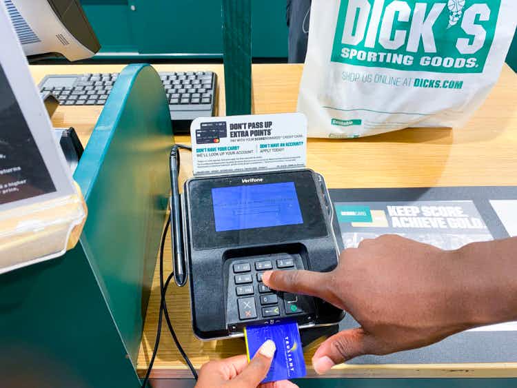 someone putting their credit card in the reader to get a return at dicks sporting goods