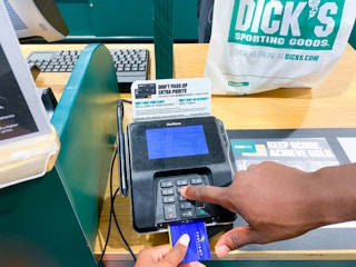 someone putting their credit card in the reader to get a return at dicks sporting goods