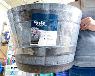 hands holding barrel planter at lowes
