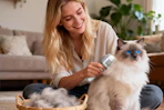 a woman brushing a cat