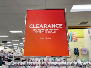 Clearance sign attached to a store rack with clothes in the background