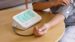 a person using a blood pressure machine at a table