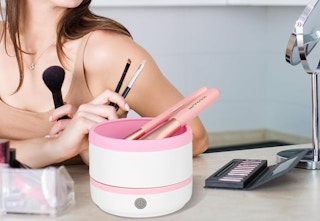 person sitting beside makeup brush cleaner