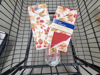 fall themed glass, dish drying mat, and towel in a cart