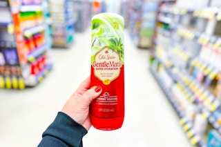 person holding a bottle of old spice body wash in an aisle