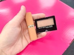 hand holding maybelline shadow and loreal lipstick in walgreens