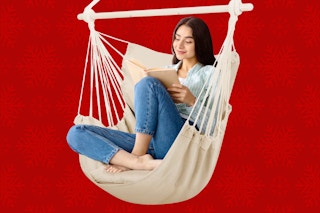 Woman siting in large beige hammock chair swing