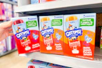 person grabbing a box of gerber get ems squeezies off the shelf