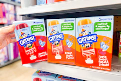 person grabbing a box of gerber get ems squeezies off the shelf