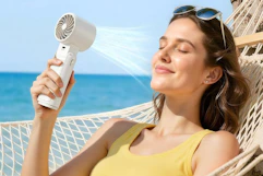 a woman using a handheld fan