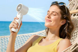 a woman using a handheld fan