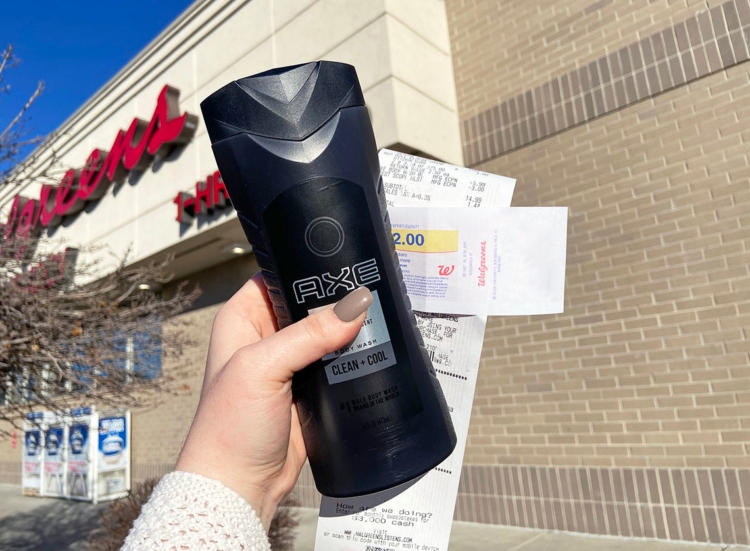 Person holding Axe body wash, coupon, and receipt outside a Walgreens