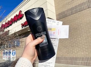 Person holding Axe body wash, coupon, and receipt outside a Walgreens