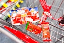 kinder joy, reeses trees, twix, and skittles candy in a cart