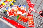 kinder joy, reeses trees, twix, and skittles candy in a cart
