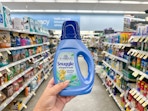 hand holding snuggle liquid fabric softener in walgreens