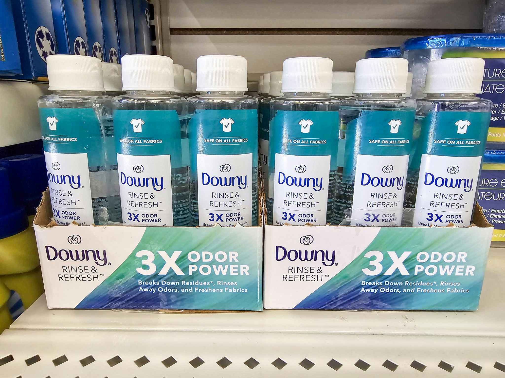 shelf with bottles of downy rinse and refresh