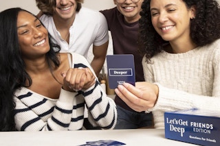 four people playing a card game at a table