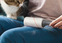 a person using a lint roller on their pants