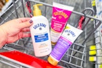 hand holding gold bond lotion with more in a shopping cart