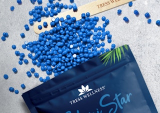 blue wax beads coming out of pouch with a wooden wax stick