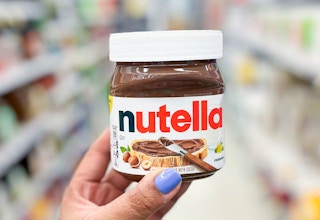 hand holding Nutella container in aisle