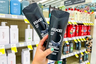 hand holding two axe body washes in a store aisle