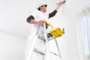 Lifestyle image of a man using the Werner Step ladder to paint the inside of a house