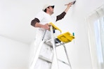 Lifestyle image of a man using the Werner Step ladder to paint the inside of a house