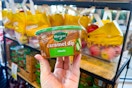 hand holding a tub of marzetti caramel dip
