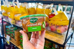 hand holding a tub of marzetti caramel dip