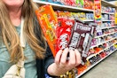 hand holding packs of Hershey's, Reese's and Kit Kat Candy Bars