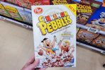 hand holding a box of post cereal