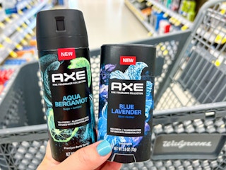Someone holding Axe Blue Lavender deodorant stick and Aqua Bergamot body spray in Walgreens
