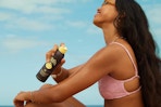 a woman spraying sun bum sunscreen