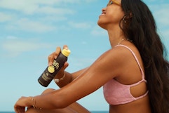 a woman spraying sun bum sunscreen