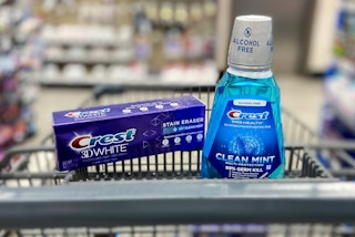 a bottle of crest mouthwash and a tube of crest toothpaste in a walgreens cart