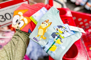 hand holding 2 bluey graphic tees at target