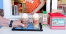 A Rita's employee serving some frozen coffees to customers