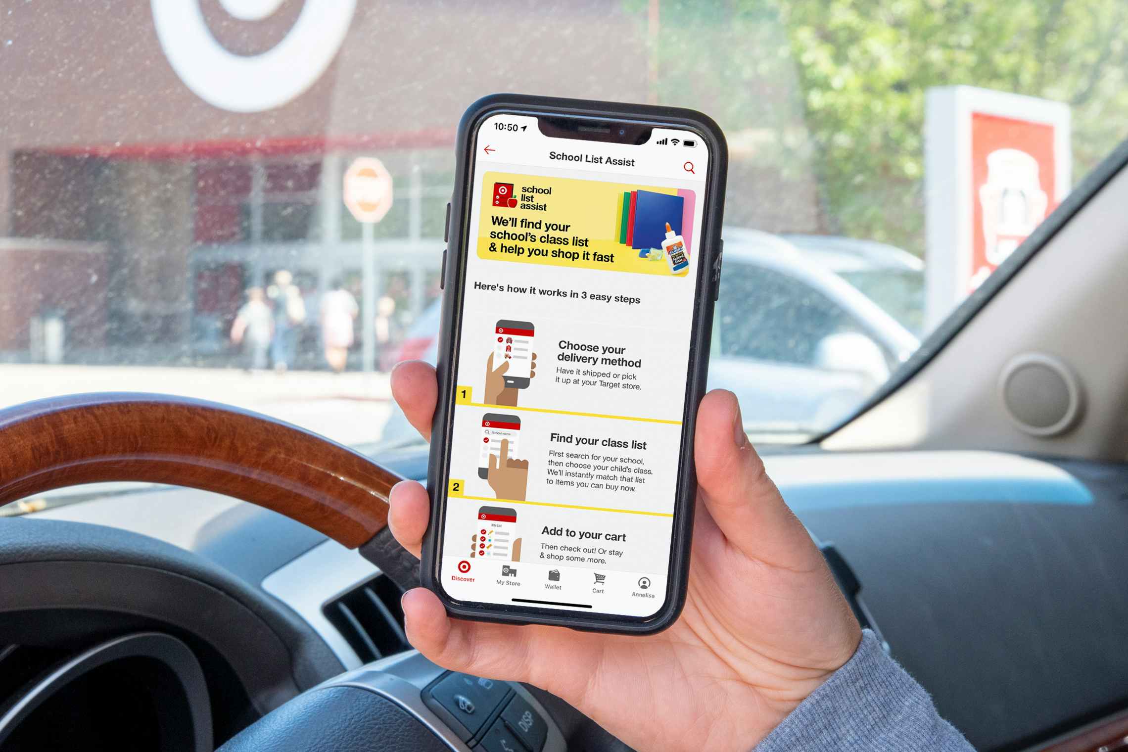 A cell phone with the Target School List Assist page open on the Target app, held by someone sitting in their vehicle in the parking lot ...