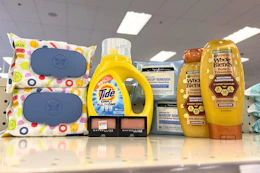 garnier whole blends shampoo, neutrogena wipes, maybelline eyeshadow, tide simply, and honest wipes on a shelf